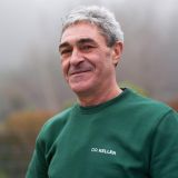 Lächelnder Mann in einem grünen Pullover mit der Aufschrift 'DR. KELLER', der vertrauenswürdig und freundlich wirkt.